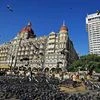 A man feeds pigeons outside the Gateway of India and Taj hotel on the eve of the eighth anniversary of 26/11 terror attack n Mumbai. Photo: PTI