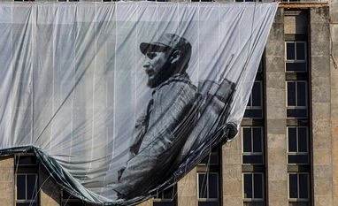 Rajnath leaves for Havana to attend Fidel Castro's commemoration Men hang a giant banner with a picture of Cuba's late leader Fidel Castro as a young revolutionary, from the Cuban National Library building in Havana