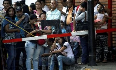No last-minute rush to deposit notes, but cash crunch may continue: Bankers Desperate to dump soon-worthless cash, Venezuelans flock to banks
