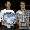 Switzerland's Roger Federer, right, and Spain's Rafael Nadal hold their trophies after Federer won their men's singles final at the Australian Open tennis championships in Melbourne, Australia.