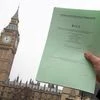 A journalist poses with a copy of the Brexit Article 50 bill, introduced by the government to seek parliamentary approval to start the process of leaving the European Union, in front of the Houses of Parliament in London, Britain