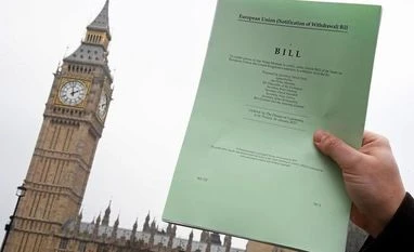 On the eve of Brexit, Qatar pledges over $6 bn in investment in Britain A journalist poses with a copy of the Brexit Article 50 bill, introduced by the government to seek parliamentary approval to start the process of leaving the European Union, in front of the Houses of Parliament in London, Britain