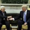 President Donald Trump reaches to shakes hands with Palestinian leader Mahmoud Abbas in the Oval Office of the White House in Washington