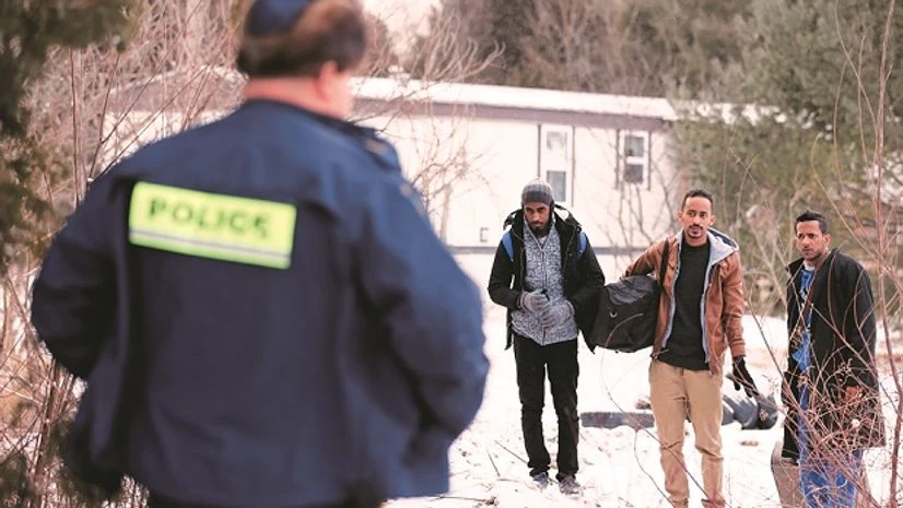 Three men who claimed to be from Sudan and were driven by taxi driver Curtis Seymour are confronted by Royal Canadian Mounted Police as they prepare to cross illegally the US-Canada border into Hemmingford, Quebec Photo: Reuters Three men who claimed to be from Sudan and were driven by taxi driver Curtis Seymour are confronted by Royal Canadian Mounted Police as they prepare to cross illegally the US-Canada border into Hemmingford, Quebec Photo: Reuters