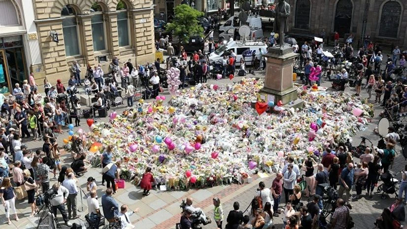 People look at tributes in a square in central Manchester, England, Thursday, May 25, 2017, ahead of a minute's silence for the victims of the suicide attack at an Ariana Grande concert that left more than 20 people dead and many more injured, as it People look at tributes in a square in central Manchester, England, Thursday, May 25, 2017, ahead of a minute's silence for the victims of the suicide attack at an Ariana Grande concert that left more than 20 people dead and many more injured, as it