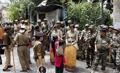 GJM activists set ablaze railway, police station after raid on chief's home Security personnel ask for the identity of a woman during a strike called by Gorkha Janmukti Morcha in Darjeeling Hills