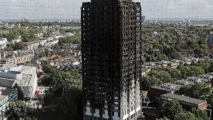 london fire attack, fire, building The scorched facade of the Grenfell Tower in London, Thursday, June 15, 2017, after a massive fire raced through the 24-storey high-rise apartment building in west London early Wednesday. (Photo:PTI/AFP)