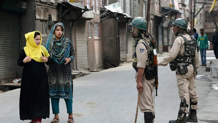 Kashmir, bandh, kashmiri, girls, army, security,J&K, unrest Girls seek permission from security personnel during restrictions imposed in the parts of the Valley following the killing of 2 civilian, in Srinagar on Friday.