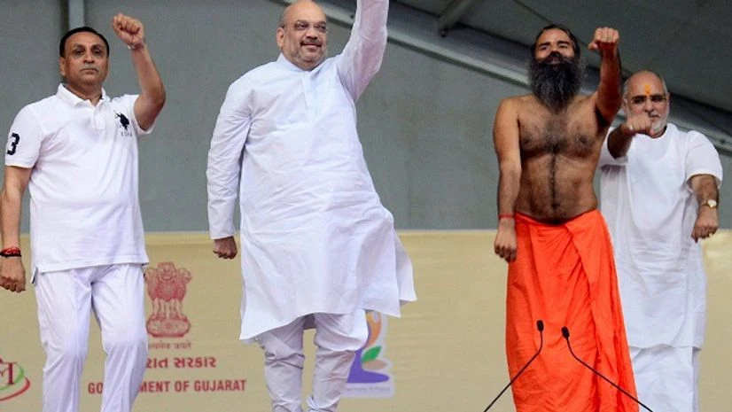 National President of BJP Amit Shah (C), Gujarat Chief Minister Vijay Rupani (L) and Yoga guru Baba Ramdev perform Yoga on the occasion of 3rd International Yoga Day at GMDC ground in Ahmedabad on Wednesday. Photo: PTI National President of BJP Amit Shah (C), Gujarat Chief Minister Vijay Rupani (L) and Yoga guru Baba Ramdev perform Yoga on the occasion of 3rd International Yoga Day at GMDC ground in Ahmedabad on Wednesday. Photo: PTI