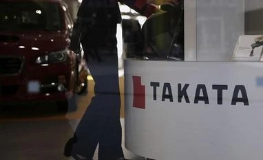 With new Takata air bag recalls, automakers may face more liabilities File photo: A woman stands next to a logo of Takata Corp at a showroom for vehicles in Tokyo, Japan