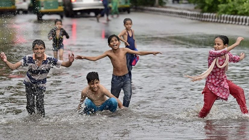 rains Children enjoy at a water logged street after heavy rains in New Delhi on Monday. Photo: PTI