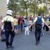 Police officers tell members of the public to leave the scene in a street in Barcelona, Spain, Thursday, Aug. 17, 2017. Police in the northern Spanish city of Barcelona say a white van has jumped the sidewalk in the city's historic Las Ramblas distri
