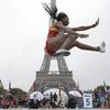 Nigerian-born Spanish athlete Juliet Itoya performs a high jump in front of the Eiffel Tower ahead of the vote in Lima, Peru, awarding the 2024 Games to the French capital, on the Champs de Mars garden in Paris