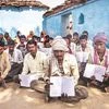 Villagers hold up their job cards for the MNREGA job scheme in Lar Sauryana village in Madhya Pradesh. Photo: Bloomberg