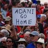 A protester holds a sign as he participates in a national Day of Action against the Indian mining company Adani's planned coal mine project in Australia. Photo: Reuters