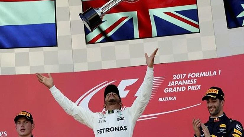 Lewis Hamilton Mercedes driver Lewis Hamilton of Britain throws his trophy aloft as he celebrates after winning the Japanese Formula One Grand Prix at Suzuka. Second placed Red Bull driver Max Verstappen of the Netherlands, left, and his teammate Daniel Ricciardo o