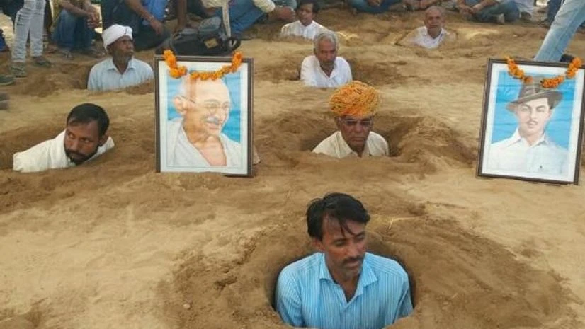 farmers, Rajasthan, land acquisition Farmers sit neck-deep in mud to protest forceful land acquisition.(Photo: Twitter)