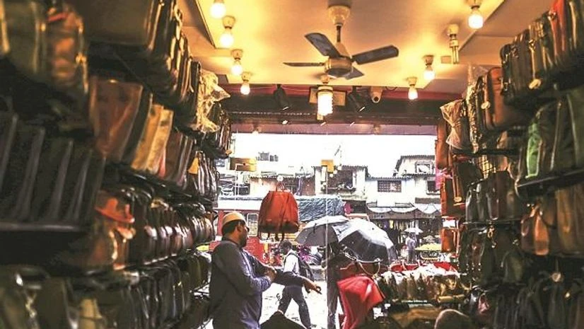 shop, shopkeeper, A vendor waits for a customers at a leather goods store in Dharavi. Photo: Bloomberg