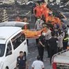 Police officers and rescuers carry a body at the site of an explosion at a firecracker factory in Tangerang, on the outskirts of Jakarta, Indonesia. Photo: AP/PTI