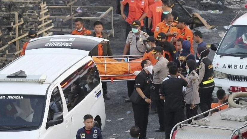 Police officers and rescuers carry a body at the site of an explosion at a firecracker factory in Tangerang, on the outskirts of Jakarta, Indonesia. Photo: AP/PTI Police officers and rescuers carry a body at the site of an explosion at a firecracker factory in Tangerang, on the outskirts of Jakarta, Indonesia. Photo: AP/PTI
