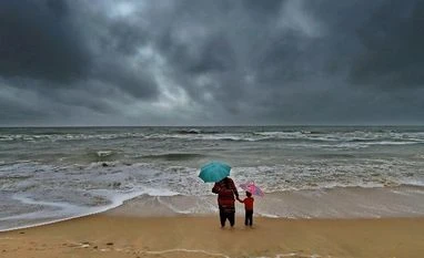 Rains to reduce gradually in coming days in TN: Met Dept File Photo: A woman standing with her son at Marina beach following heavy downpour due to the onset of northeast monsoon in Chennai.