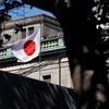 A Japanese flag flutters atop the Bank of Japan building under construction in Tokyo. Photo: Reuters