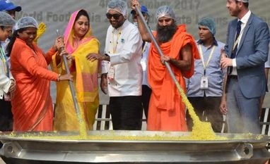 India attempts world record with 800 kg Khichdi: All you need to know Sadhvi Niranjan Jyoti, MoS for Food Processing Harsimrat Kaur Badal, Minister of Food Processing,chef sanjeev kapoor,Baba Ramdev giving final touches to 800kg khichidi an attempt to get into Guinness book of World Records