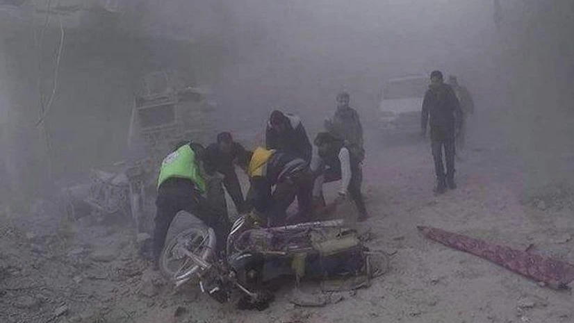 Syria attack Douma : In this photo provided by the Syrian Civil Defense group in Damascus suburbs known as the White Helmets, Civil Defense workers carry an injured man after government airstrikes hit Douma, near Damascus, Syria. (Photo: AP/PTI)