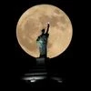 A supermoon rises in front of a replica of the Statue of Liberty sitting atop the Liberty Building in downtown Buffalo, N.Y. Photo: Reuters