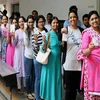 People wait in a queue to cast their votes for the second phase of assembly elections in Ahmedabad