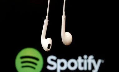 Global online music streaming revenue declines 2% in Q2, shows report Headphones are seen in front of a logo of online music streaming service Spotify