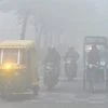 People commute in thick fog in New Delhi on  Sunday morning. Photo: PTI