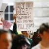 A student holds a sign addressing the National Rifle Association during a demonstration calling for safer gun laws outside the North Carolina State Capitol building.