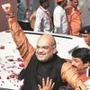 BJP President Amit Shah greets party workers as they celebrate outside the party headquarters in New Delhi. (Photo: PTI)