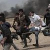 Palestinian protesters evacuate a wounded youth during clashes with Israeli troops along Gaza's border with Israel, east of Khan Younis, Gaza Strip, on Friday. | Photo: AP/PTI