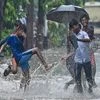 Boys play at a flooded road during rains, in Mumbai on Tuesday