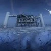 In this artistic composition, based on a real image of the IceCube Lab at the South Pole, a distant source emits neutrinos that are detected below the ice by IceCube sensors, called DOMs