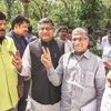 Deputy Chairman of Rajya Sabha Harivansh (right) flashes the victory sign as Union Minister Ravi Shankar Prasad looks on, outside Parliament. Photo: PTI