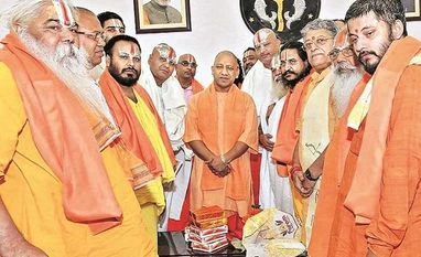BJP will junk the plank of development and fight 2019 elections on faith Uttar Pradesh CM Yogi Adityanath with a delegation of seers during a recent meeting over early construction of Ram Temple at Ayodhya