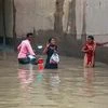 Mirzapur: Pedestrians wade through a waterlogged street following monsoon rainfall, in Mirzapur on Monday, Sept 3, 2018. Photo: PTI