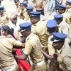 Police escort Madhavi (of Andhra Pradesh) and her family members after she was heckled by the protesters while she was seeking the entry to the Lord Ayyappa Temple on its opening day in Sabarimala, Kerala, Wednesday | Photo: PTI