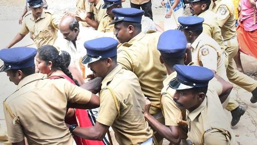 sabarimala protest, sabarimala, sabarimala temple, lord ayappa Police escort Madhavi (of Andhra Pradesh) and her family members after she was heckled by the protesters while she was seeking the entry to the Lord Ayyappa Temple on its opening day in Sabarimala, Kerala, Wednesday | Photo: PTI