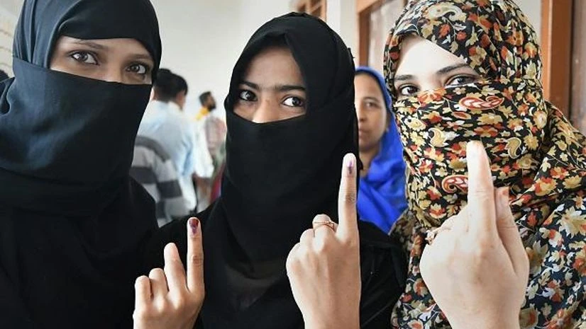 Voters, polls, elections Muslim women show their fingers marked with indelible ink after casting votes for the Assembly elections, outside a polling station in Bhopal, Madhya Pradesh. Photo: PTI