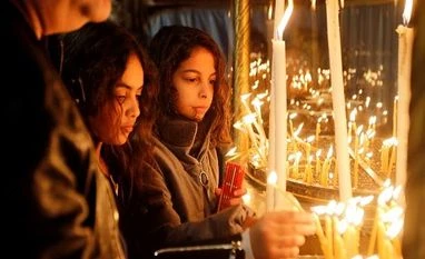 Bethlehem boasts largest Christmas in years as millions flock to the city Girls light candles at the Church of the Nativity, in Bethlehem in the Israeli-occupied West Bank
