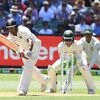 India's Mayank Agarwal (L) plays a shot as Australia's Tim Paine (C) and Usman Khawaja look on during day one of the third test match between Australia and India at the MCG in Melbourne, Australia