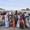 Pilgrims wait to board their buses at Babughat transit camp on their way to Gangasagar Mela, in Kolkata