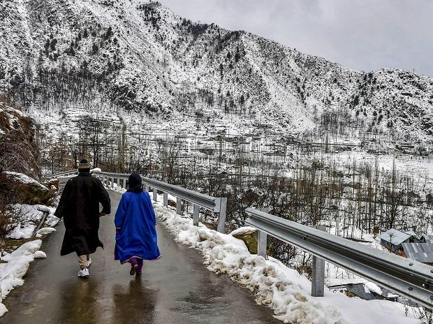 People strolling along a snow-covered path amid light rains People strolling along a snow-covered path amid light rains