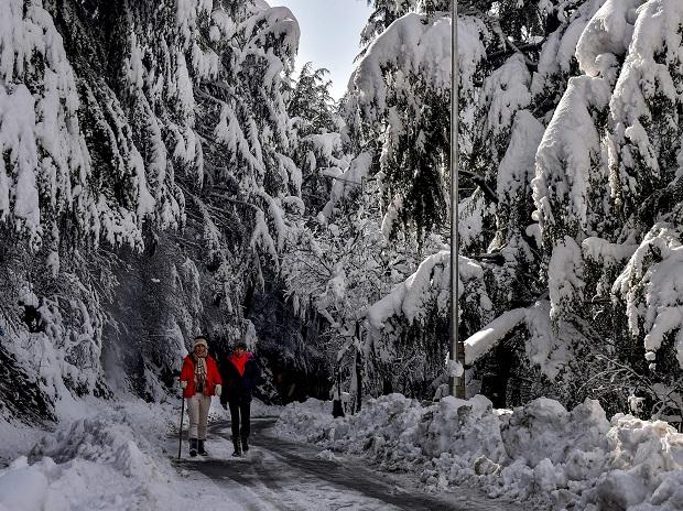 Tourists walk on a snow-covered trail after a spell of heavy snowfall, in Srinagar Tourists walk on a snow-covered trail after a spell of heavy snowfall, in Srinagar