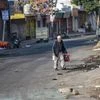 Jammu: An elderly man walks along a street during a curfew imposed after clashes between two communities over the protest against the Pulwama terror attack, in Jammu, Saturday. PTI Photo