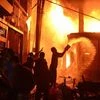 In this Wednesday, Feb. 20, 2019, photo, firefighters and local people help to douse a fire in Dhaka, Bangladesh. A devastating fire raced through at least five buildings in an old part of Bangladesh's capital and killed scores of people. Photo: AP
